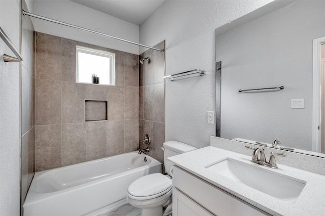 full bathroom with vanity, tiled shower / bath combo, and toilet