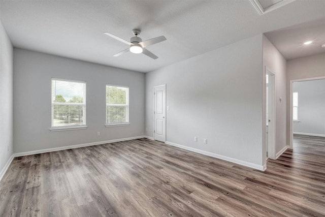 spare room featuring ceiling fan, hardwood / wood-style floors, and a wealth of natural light