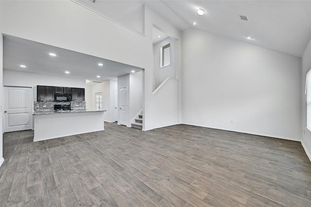 unfurnished living room featuring high vaulted ceiling, a wealth of natural light, and dark hardwood / wood-style floors