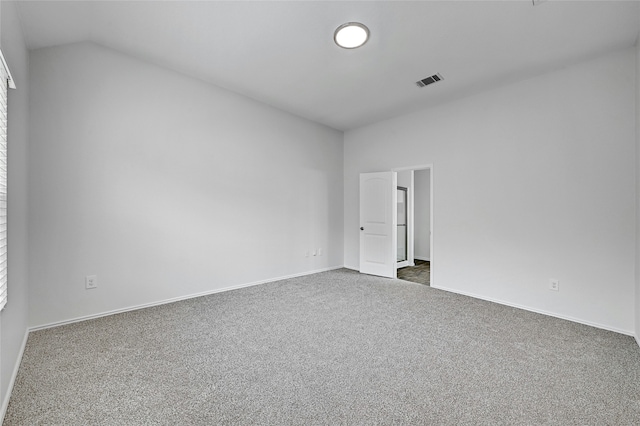 carpeted spare room featuring lofted ceiling