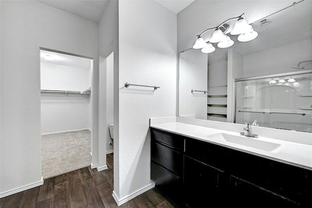 bathroom with vanity, toilet, an enclosed shower, and hardwood / wood-style flooring