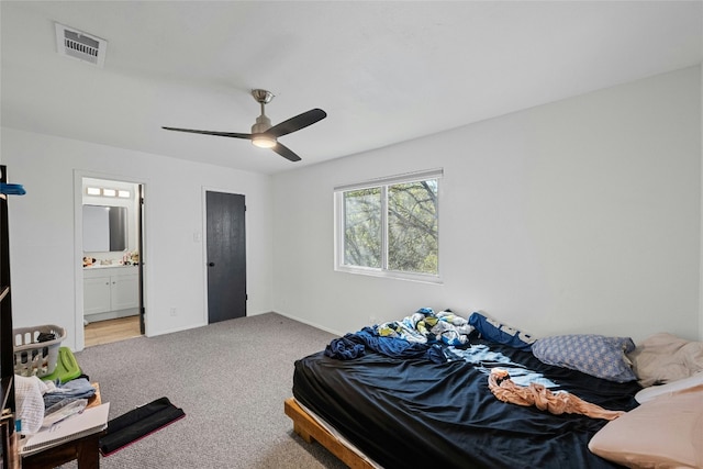 bedroom featuring ceiling fan, light colored carpet, and ensuite bathroom