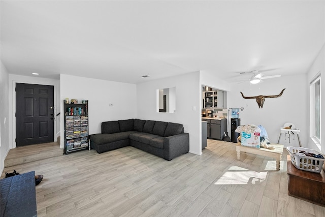 living room featuring ceiling fan and light wood-type flooring