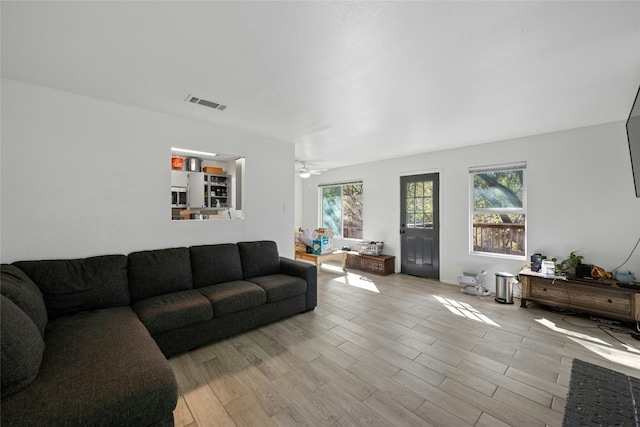 living room with light hardwood / wood-style flooring and ceiling fan