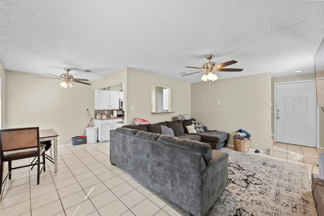 tiled living room with a textured ceiling and ceiling fan