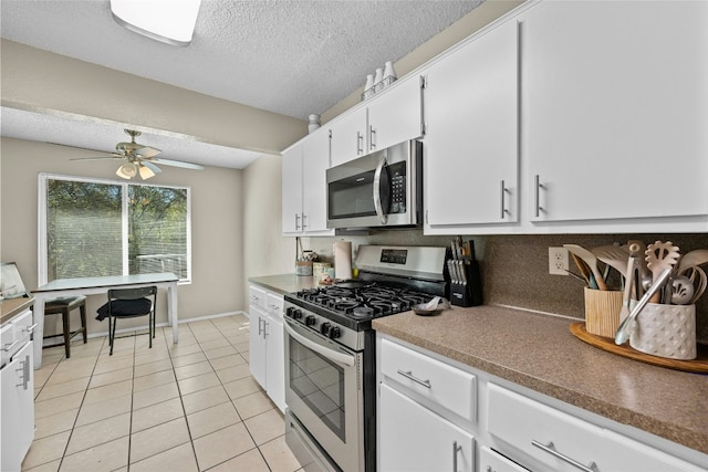 kitchen featuring white cabinets, ceiling fan, light tile patterned floors, a textured ceiling, and appliances with stainless steel finishes