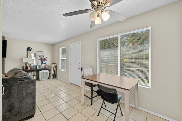 tiled dining area featuring ceiling fan, a healthy amount of sunlight, and a textured ceiling