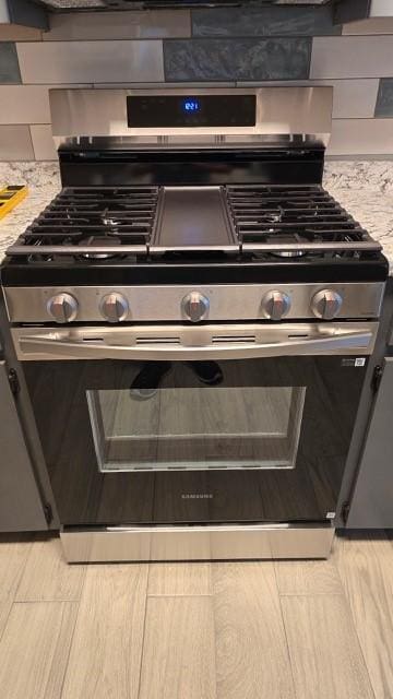 interior details with light stone countertops and high end stainless steel range oven