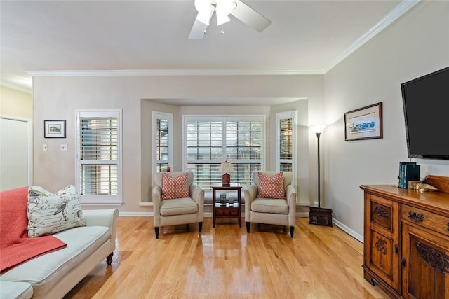 living area with light wood finished floors, baseboards, crown molding, and a ceiling fan