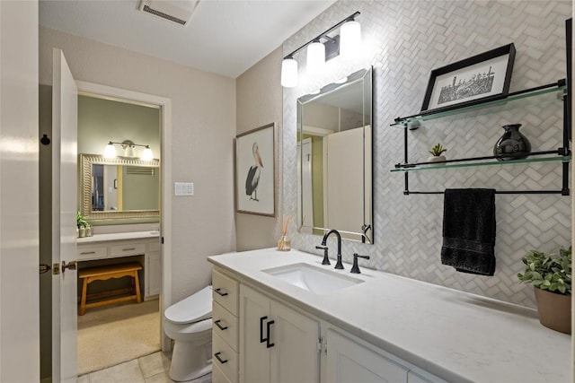 bathroom featuring tile patterned flooring, vanity, and toilet