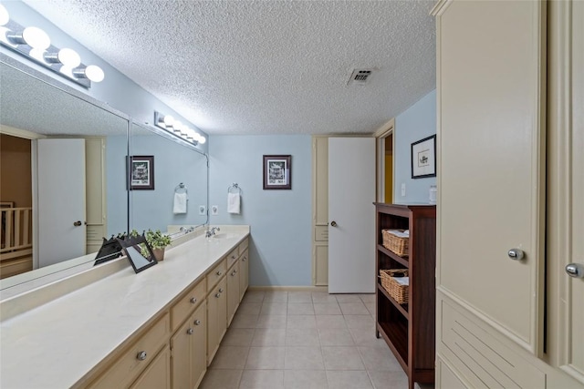 bathroom with vanity, tile patterned floors, visible vents, and a textured ceiling