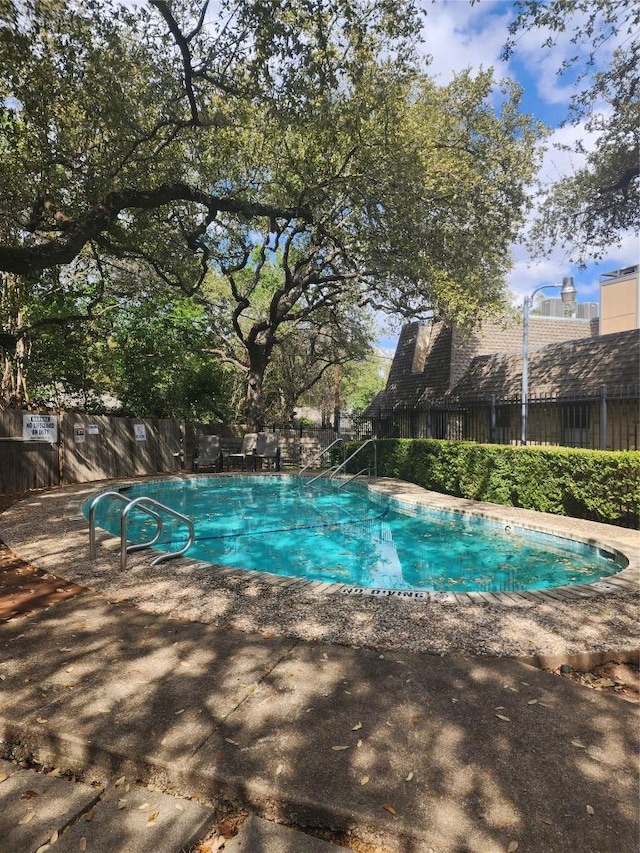 view of swimming pool featuring a fenced in pool and fence