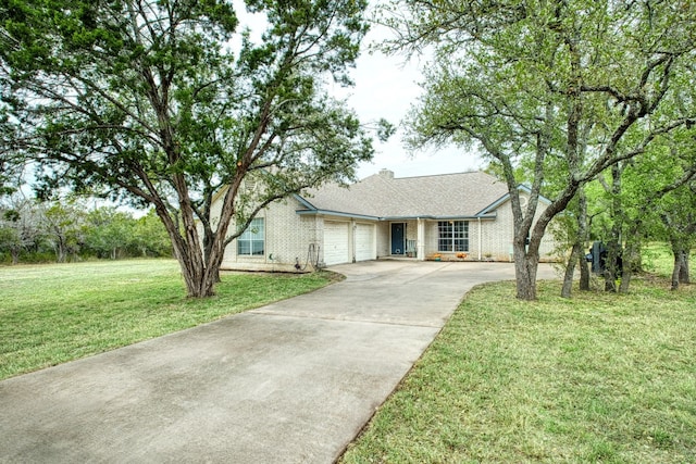 ranch-style house featuring brick siding, a front lawn, an attached garage, and driveway