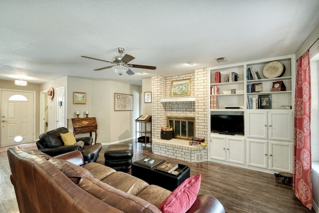 living area with visible vents, a ceiling fan, a textured ceiling, dark wood-style floors, and a fireplace