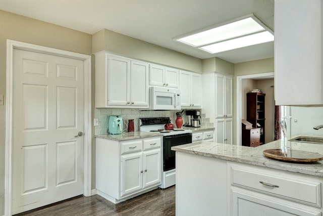 kitchen with electric range, a sink, dark wood finished floors, white cabinets, and white microwave