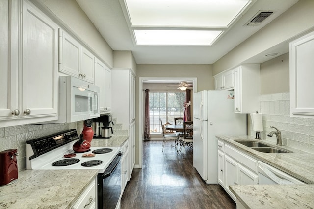 kitchen with visible vents, a sink, white cabinetry, white appliances, and dark wood-style flooring