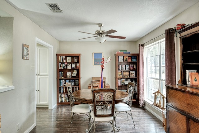 dining room with a ceiling fan, wood finished floors, visible vents, and baseboards