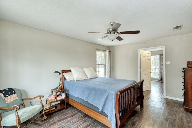 bedroom featuring visible vents, a textured ceiling, ceiling fan, and wood finished floors