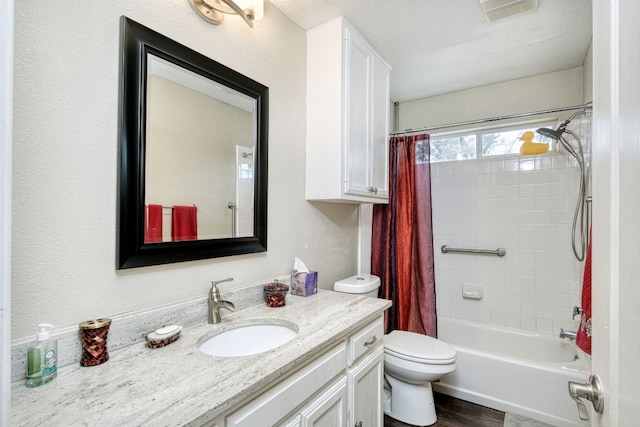 bathroom featuring visible vents, toilet, shower / tub combo, wood finished floors, and vanity