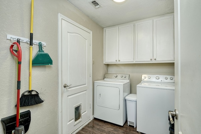 laundry area with visible vents, washer and dryer, a textured ceiling, cabinet space, and dark wood-style flooring