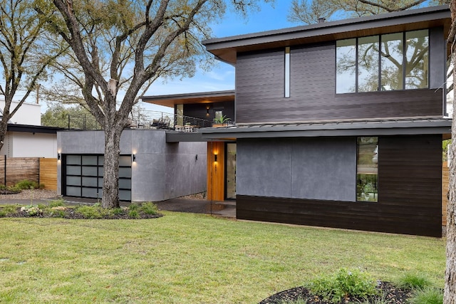 modern home featuring a balcony and a front lawn