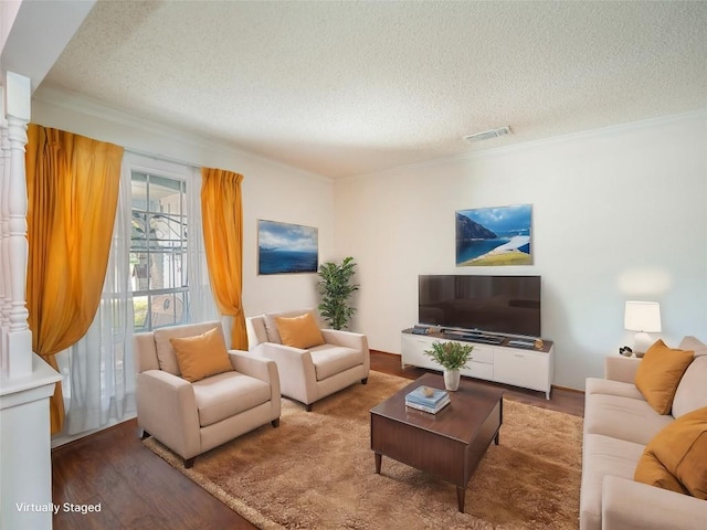 living room featuring crown molding, hardwood / wood-style floors, and a textured ceiling