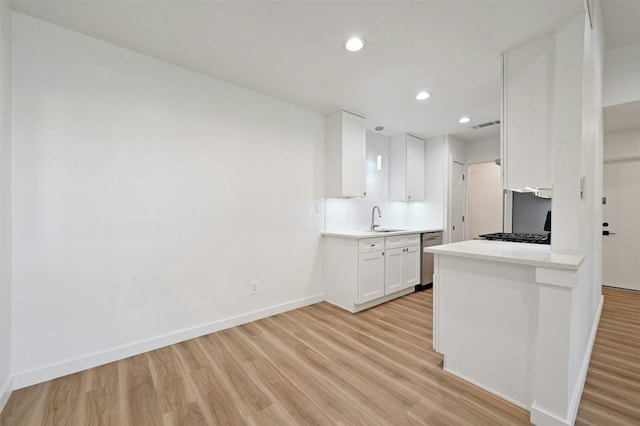 kitchen featuring white cabinetry, sink, dishwasher, and light wood-type flooring