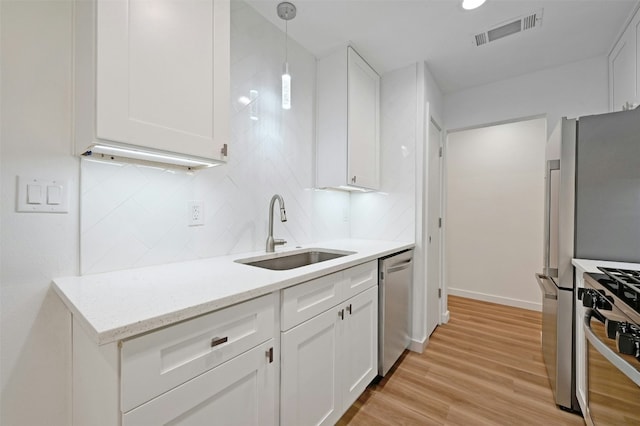 kitchen featuring light hardwood / wood-style floors, white cabinetry, sink, and stainless steel appliances