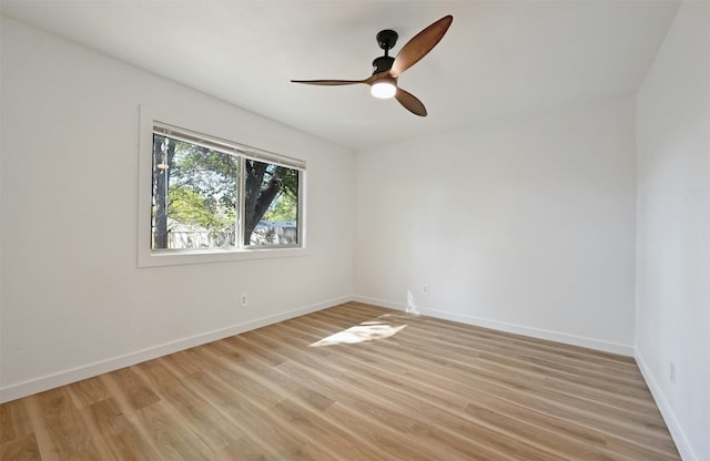 empty room with ceiling fan and light hardwood / wood-style flooring