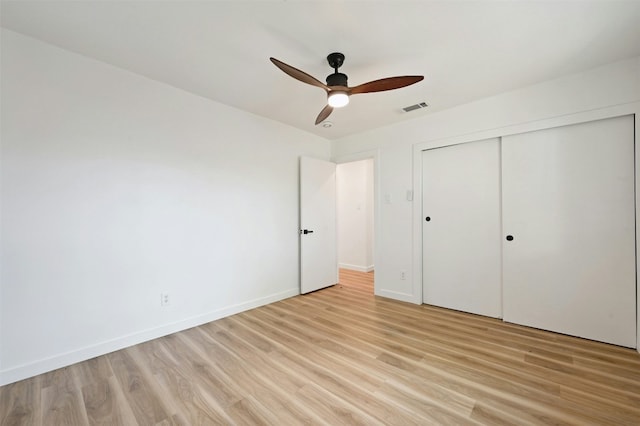 unfurnished bedroom featuring light wood-type flooring, a closet, and ceiling fan