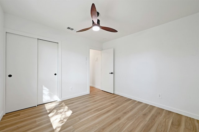 unfurnished bedroom featuring ceiling fan, a closet, and light hardwood / wood-style flooring