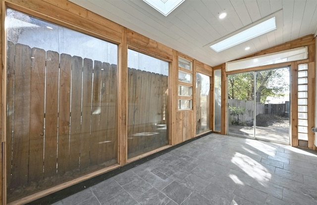 unfurnished sunroom with vaulted ceiling with skylight