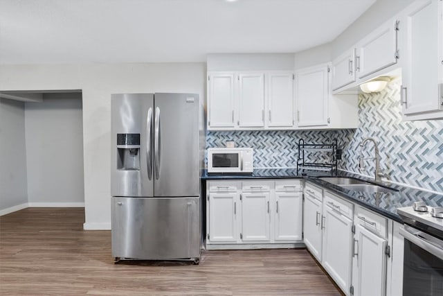 kitchen featuring white cabinetry, sink, stainless steel appliances, tasteful backsplash, and dark hardwood / wood-style flooring