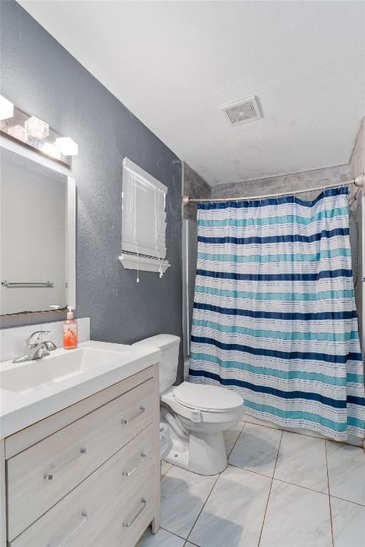 bathroom with vanity, toilet, and curtained shower