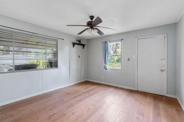 empty room with ceiling fan and light hardwood / wood-style flooring