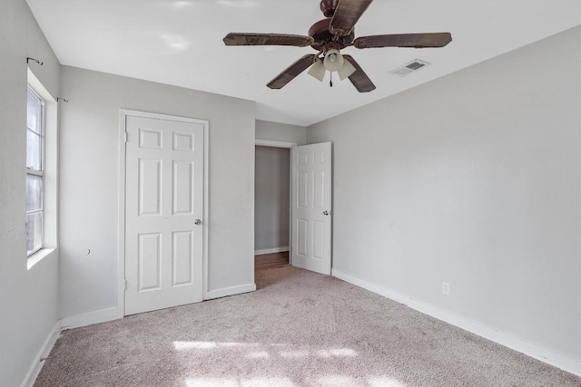 unfurnished bedroom with light colored carpet and ceiling fan