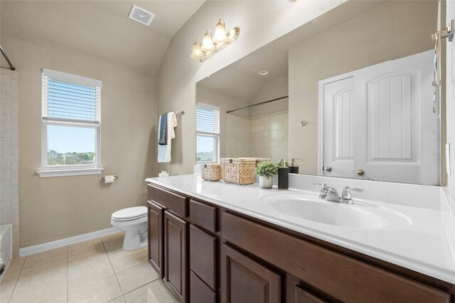 bathroom with tile patterned flooring, vanity, vaulted ceiling, and toilet