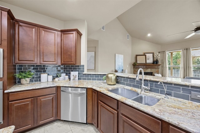 kitchen with lofted ceiling, backsplash, sink, stainless steel dishwasher, and light tile patterned flooring