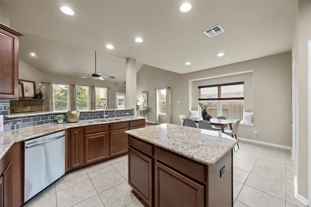 kitchen featuring ceiling fan, dishwasher, sink, lofted ceiling, and decorative backsplash