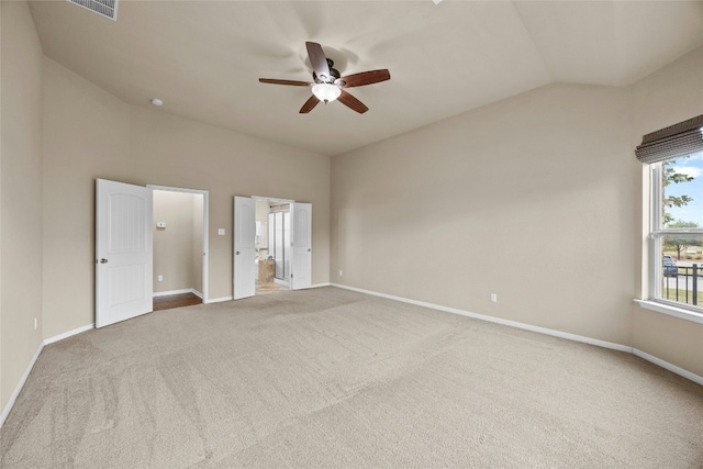 empty room with ceiling fan, carpet floors, and vaulted ceiling