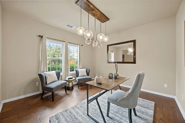 office with dark hardwood / wood-style flooring and a notable chandelier