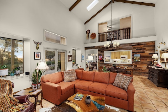 tiled living room with high vaulted ceiling, french doors, wooden walls, a notable chandelier, and beam ceiling