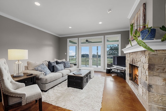 living room featuring ceiling fan, a stone fireplace, crown molding, and french doors