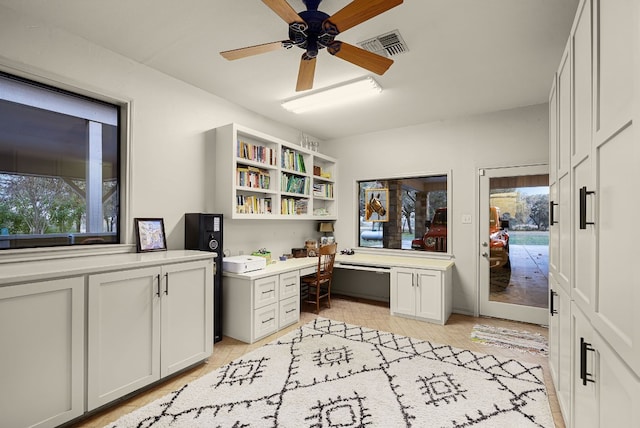 office area with built in desk, light hardwood / wood-style flooring, and ceiling fan