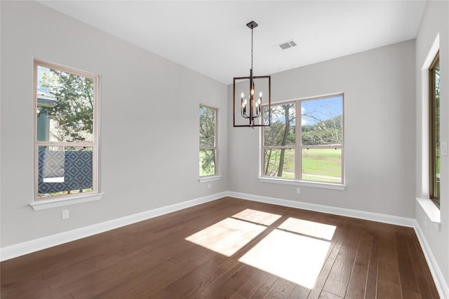 unfurnished dining area featuring a notable chandelier and dark wood-type flooring