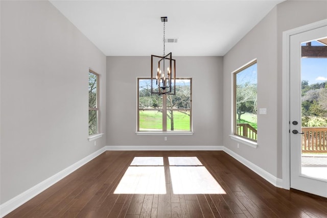 unfurnished dining area featuring dark hardwood / wood-style floors and a notable chandelier