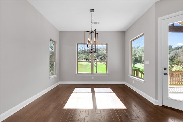 20701 Deep Crk, Lago Vista, TX 78645 - unfurnished dining area with a chandelier, dark wood-style floors, and baseboards