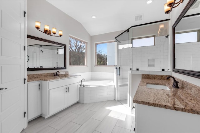 20701 Deep Crk, Lago Vista, TX 78645 - bathroom featuring vaulted ceiling, a bath, a stall shower, two vanities, and recessed lighting