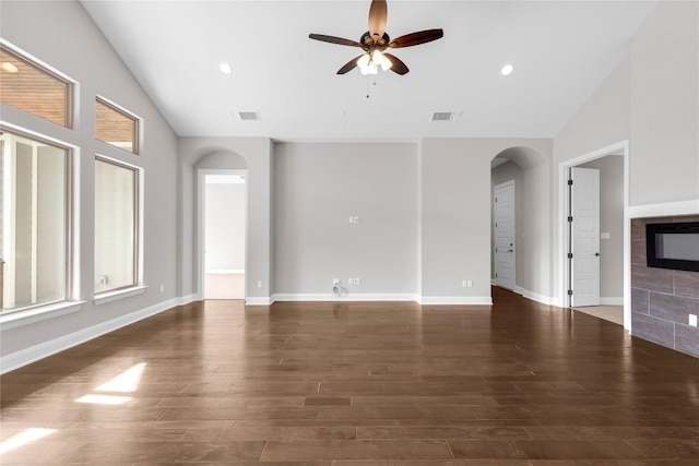 unfurnished living room with dark hardwood / wood-style floors, ceiling fan, a fireplace, and vaulted ceiling