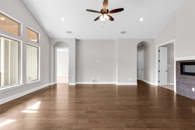 20701 Deep Crk, Lago Vista, TX 78645 - unfurnished living room with arched walkways, vaulted ceiling, a ceiling fan, wood finished floors, and a fireplace